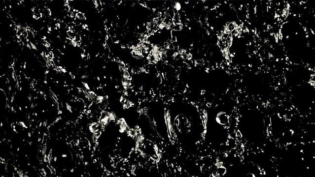 Water droplets rotate in flight. Top view. On a black background. Filmed on a high-speed camera at 1000 fps.