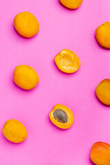 Apricot pattern. Top view of fresh fruit on a pink background. Repetition concept