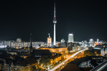 berlin alexanderplatz and tv tower night time hot with long exposure traffic lights with buildings and grey yellow colors scheme