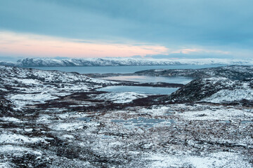 Harsh Arctic landscape. Frozen tundra with icy lakes at dawn. Amazing northern nature.