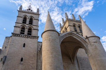 Low angle view of ancient St Pierre or St Peter's cathedral bell towers and entrance portal, famous historic landmark of Montpellier, France
