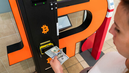 Atm machine bitcoin cryptocurrency. Usd hundred money payment on virtual crypto currency btc wallet. Woman withdraw american dollar bill money. Atm machine finance and technology concept.