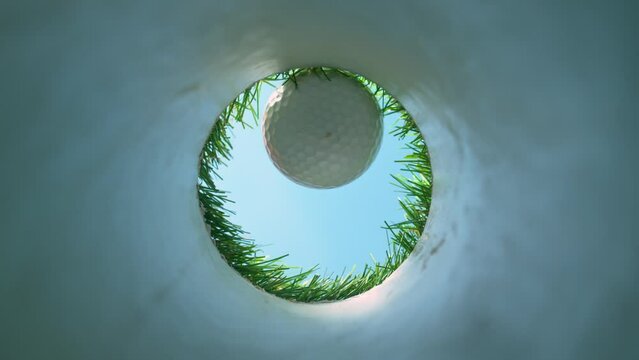 Super Slow Motion Shot of Golf Ball Falling Down Through Hole at 1000 fps.
