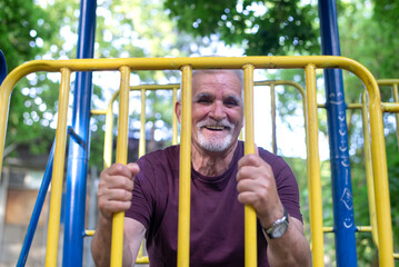 Obraz premium Happy sporty senior man stretching in the morning before exercise.