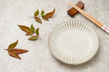 紅葉した南天の葉と食器の背景。食欲の秋。