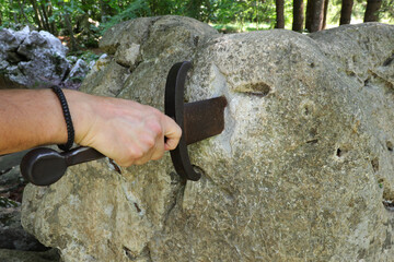 hand and sword in the stone as in the legend of King Arthur