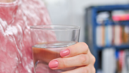 Close up of young woman drinking glass of pure still water