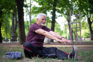 Naklejka na ściany i meble Happy sporty senior man stretching in the morning before exercise.
