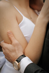 Portrait of elegant newlyweds hugging on the street on a summer day. 