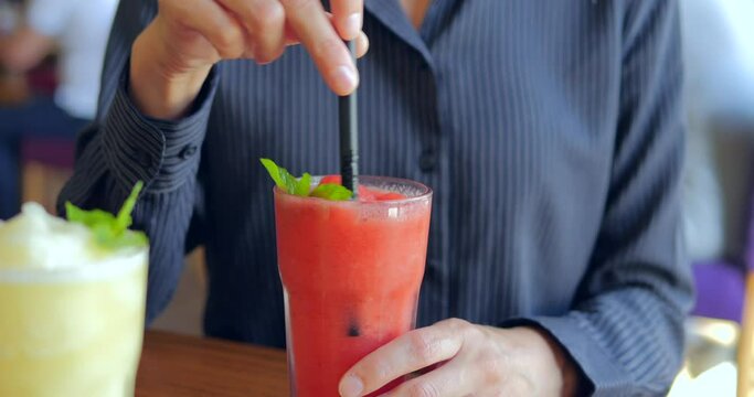 Happy business woman drinking healthy strawberry banana smoothie from straw
