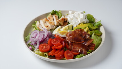 American cobb salad hard boiled eggs, cheese, avocado chunks, lettuce, grilled chicken breast, tomatoes and crispy fried bacon
