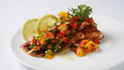 Glazed salmon fillet with mango salsa, herbs and lemon
