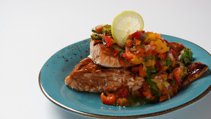 Glazed salmon fillet with mango salsa, herbs and lemon