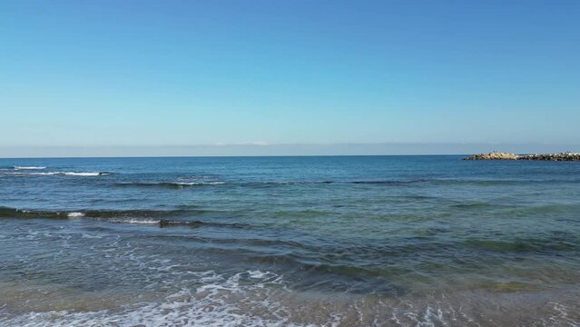 Sea waves gently crash on the beach coast. Givat Alia, Jaffa, Israel. High quality 4k footage