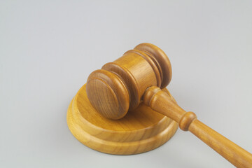 Wooden judge gavel on gray background close up. Laws, justice, court and legal system concept.