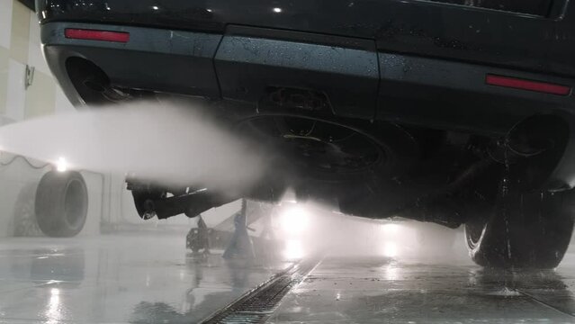 Washing the bottom of the car with strong water pressure in the car wash