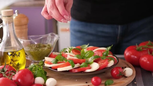  salting caprese salad - mozzarella cheese balls, sliced cherry tomatoes and basil
