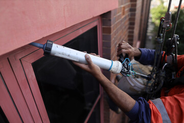 Rope access abseiler handyman building repair commercial services wearing full arrest safety body...