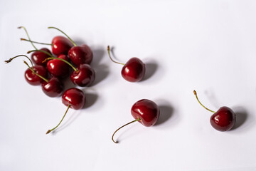 Fototapeta na wymiar Three cherries lay separately from group of cherries