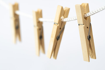 Den Helder, Netherlands. July 2022. Wooden clothes pegs on a white background. Selective focus.