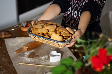 Christmas food concept. Child is holding gingerbread man cookies in basket. Xmas dessert.