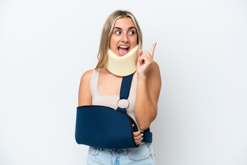 Woman with broken arm and wearing a sling isolated on white background intending to realizes the solution while lifting a finger up