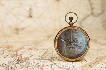 Fototapeta na wymiar Old vintage compass on ancient map background. Travel, geography, navigation concept