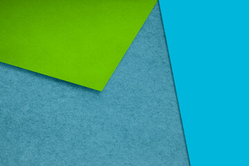 Plain and Textured neon green sea blue papers randomly laying to form M like pattern and triangle for creative cover design idea