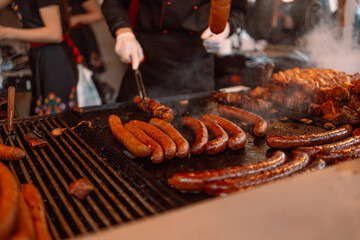 Blurry background of bbq street food for sale. Fried baked sausages, hot dog on street food outdoor market stall in Krakow Poland 