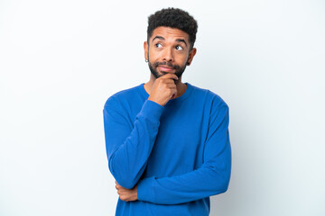 Young Brazilian man isolated on white background thinking an idea while looking up