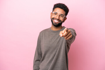 Fototapeta premium Young Brazilian man isolated on pink background pointing front with happy expression