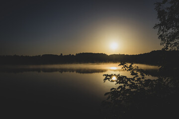 fog over the forest lake at sunrise