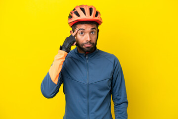 Young cyclist Brazilian man isolated on yellow background thinking an idea