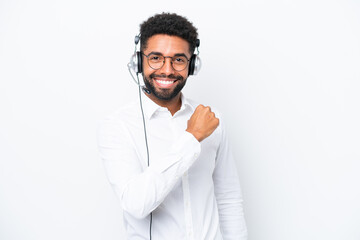 Telemarketer Brazilian man working with a headset isolated on white background celebrating a victory