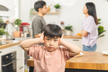 Little asian sad boy, unhappy while parents fighting, kid son not listen to shouting noise while...