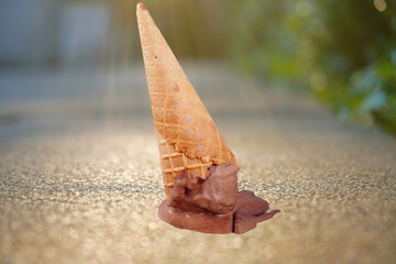 Chocolate cone ice cream falling on the ground, close-up (spot f