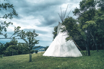 white teepee indian tent standing in beautiful landscape.