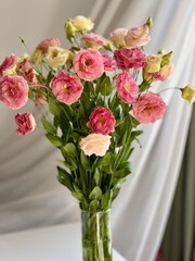 pink and yellow flowers in a vase on the table