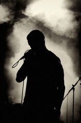 Silhouette of the singer singing on the stage