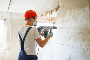 Repairer in boilersuit holding tools. Apartment repair and renovation concept. Building, working equipment and people concept.