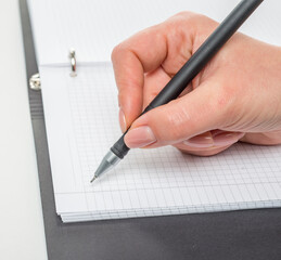 hand with a pen writes close-up isolated on a white background