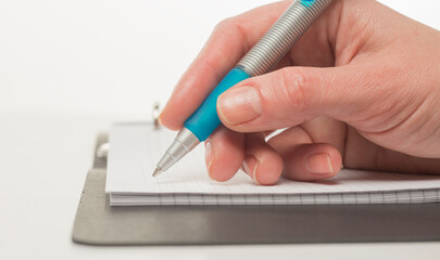 hand with a pen writes close-up isolated on a white background