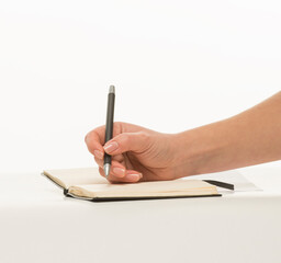 hand with a pen writes close-up isolated on a white background
