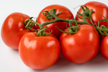 Six red fresh tomatoes on a branch isolated on white background. Fresh tomatoes on white background.