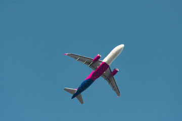 Airplane taking off and rising against clear blue sky
