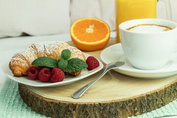 Fresh croissant and coffee on a wooden rustic background