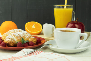 Fresh croissant and coffee on a wooden rustic background