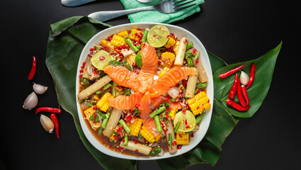 Top view, spicy mixed salad, shrimp, squid, salmon, Thai food on black table