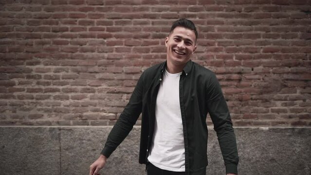 Handsome hispanic guy shows joy with a playful smile in slow motion