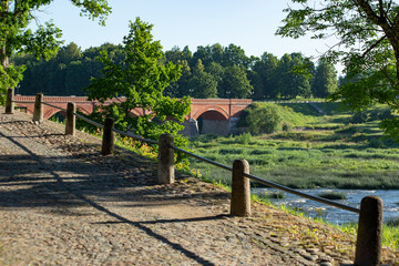 Beautiful view on Scenic road to the old brick bridge over the city park over the river. High...
